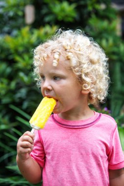  sarışın kıvırcık saçlı küçük çocuk dondurma yiyor 