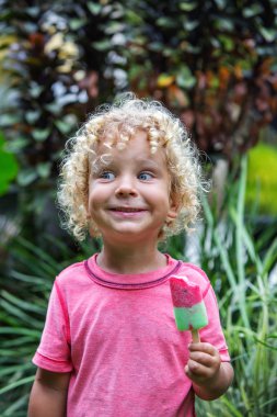  sarışın kıvırcık saçlı küçük çocuk dondurma yiyor 