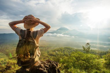 Batur, Bali, Indon dağının tepesinden gün doğumunun tadını çıkaran kadın