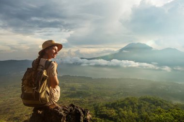 Batur, Bali, Indon dağının tepesinden gün doğumunun tadını çıkaran kadın