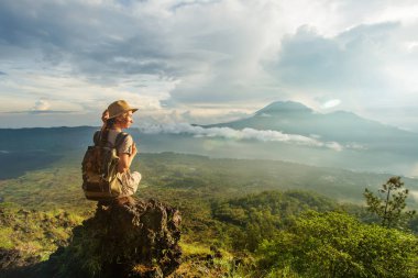 Batur, Bali, Indon dağının tepesinden gün doğumunun tadını çıkaran kadın