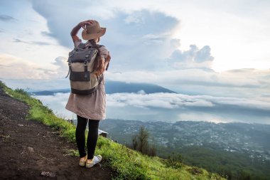 Batur, Bali, Indon dağının tepesinden gün doğumunun tadını çıkaran kadın