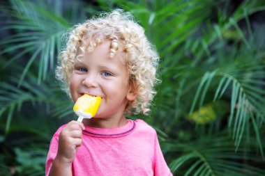  sarışın kıvırcık saçlı küçük çocuk dondurma yiyor 