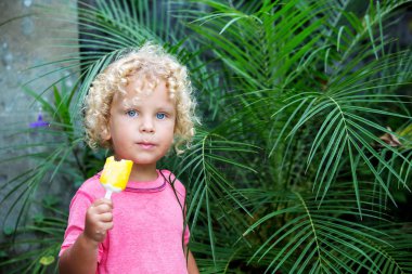  sarışın kıvırcık saçlı küçük çocuk dondurma yiyor 