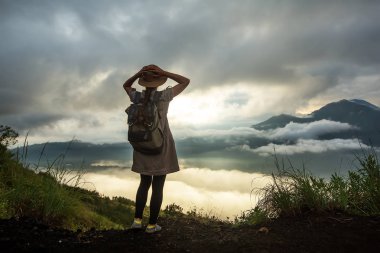 Batur, Bali, Indon dağının tepesinden gün doğumunun tadını çıkaran kadın