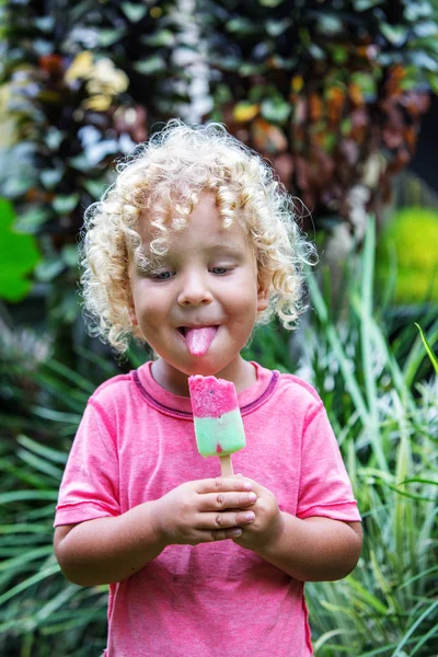 Niño pequeño con el pelo rubio rizado está comiendo helado — Foto de Stock