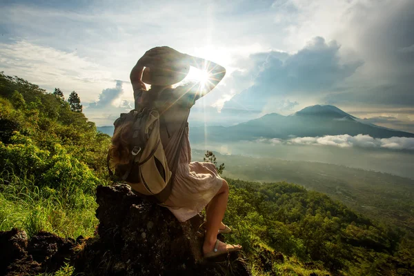 Batur, Bali, Indon dağının tepesinden gün doğumunun tadını çıkaran kadın
