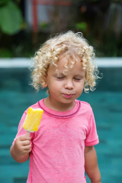  sarışın kıvırcık saçlı küçük çocuk dondurma yiyor 