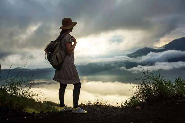 Batur, Bali, Indon dağının tepesinden gün doğumunun tadını çıkaran kadın