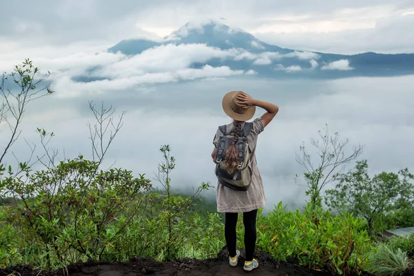 Batur, Bali, Indon dağının tepesinden gün doğumunun tadını çıkaran kadın