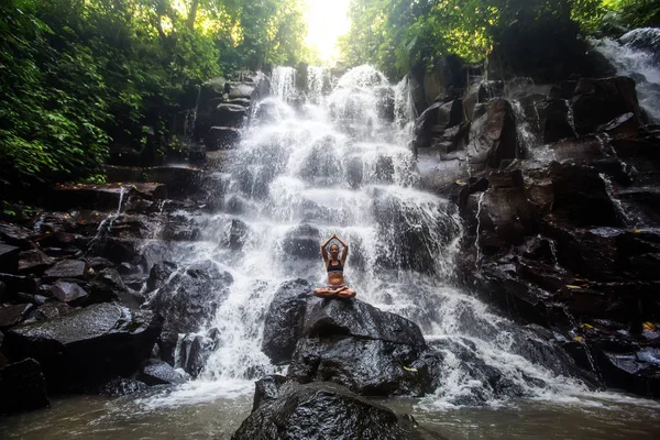 Femme pratique le yoga près d'une cascade à Bali, Indonésie — Photo