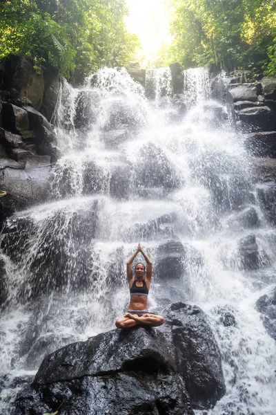 Mulher pratica ioga perto de cachoeira em Bali, Indonésia — Fotografia de Stock