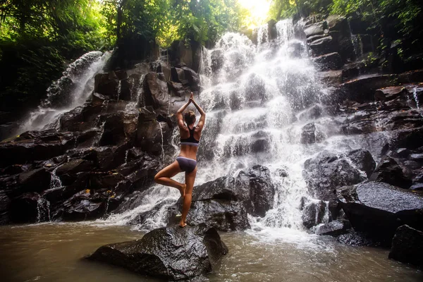 Mulher pratica ioga perto de cachoeira em Bali, Indonésia — Fotografia de Stock