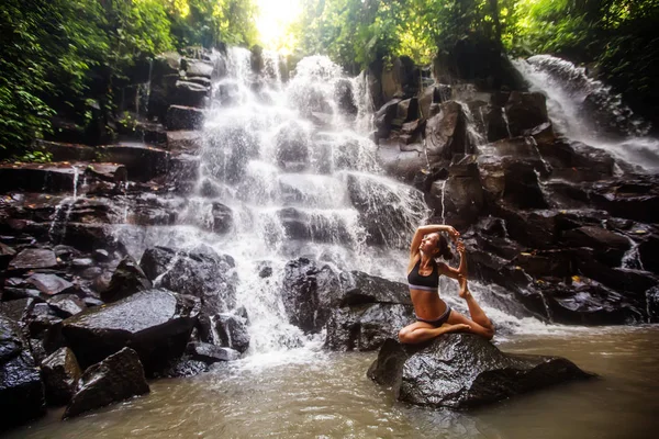 Mulher pratica ioga perto de cachoeira em Bali, Indonésia — Fotografia de Stock