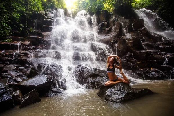 Mujer practica yoga cerca de cascada en Bali, Indonesia — Foto de Stock