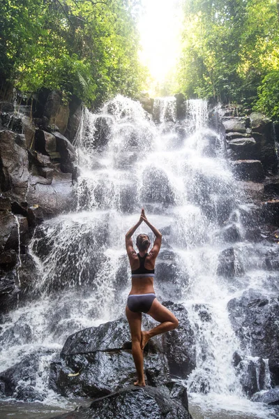 Mulher pratica ioga perto de cachoeira em Bali, Indonésia — Fotografia de Stock