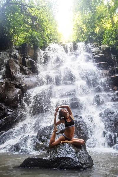 Vrouw beoefent yoga nabij waterval in Bali, Indonesië — Stockfoto