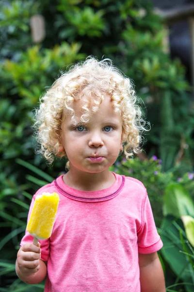  sarışın kıvırcık saçlı küçük çocuk dondurma yiyor 