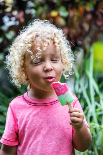 Niño pequeño con el pelo rubio rizado está comiendo helado — Foto de Stock