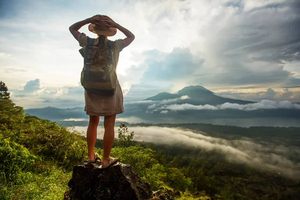 Batur, Bali, Indon dağının tepesinden gün doğumunun tadını çıkaran kadın