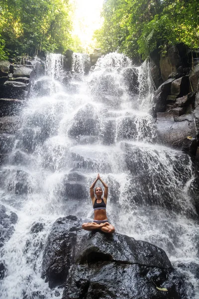 Mulher pratica ioga perto de cachoeira em Bali, Indonésia — Fotografia de Stock