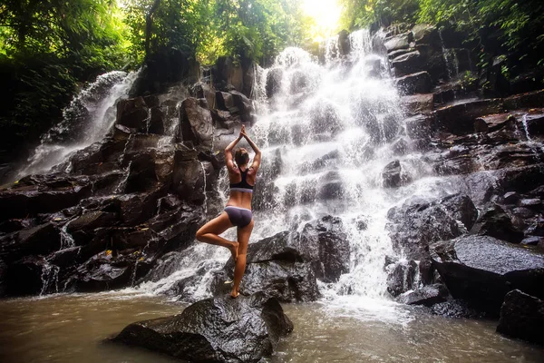 Mulher pratica ioga perto de cachoeira em Bali, Indonésia — Fotografia de Stock