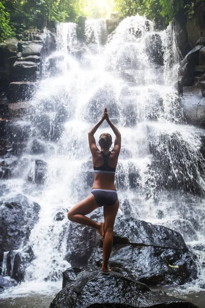 Mulher pratica ioga perto de cachoeira em Bali, Indonésia — Fotografia de Stock