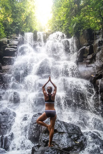 Mulher pratica ioga perto de cachoeira em Bali, Indonésia — Fotografia de Stock