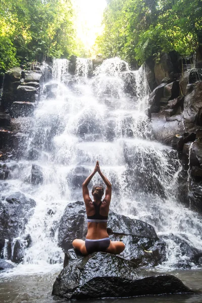 Mulher pratica ioga perto de cachoeira em Bali, Indonésia — Fotografia de Stock