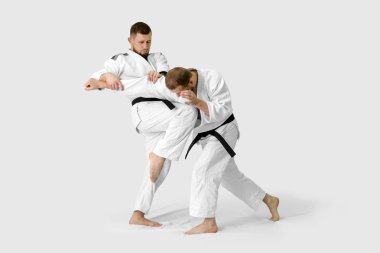 İki beyaz adam tatami üzerinde aikido yapıyor (izolasyon)