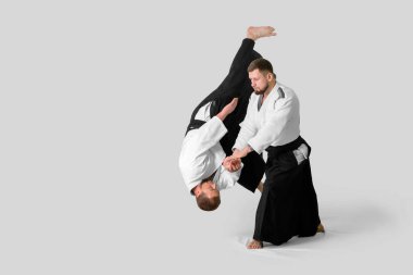 İki beyaz adam tatami üzerinde aikido yapıyor (izolasyon)