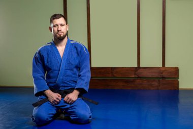 İki beyaz adam tatami üzerinde aikido çalışıyor.
