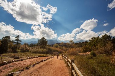 Oğluyla dağlarda yürüyüş yapan bir adam.
