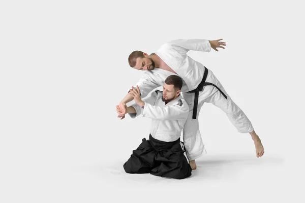 Due uomini caucasici praticano l'aikido sul tatami (isolamento — Foto Stock