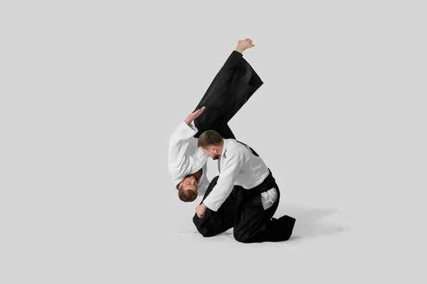 Dos hombres caucásicos practican aikido en el tatami (aislamiento — Foto de Stock