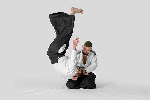 Due uomini caucasici praticano l'aikido sul tatami (isolamento — Foto Stock