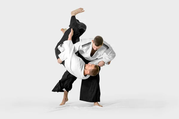 Due uomini caucasici praticano l'aikido sul tatami (isolamento — Foto Stock