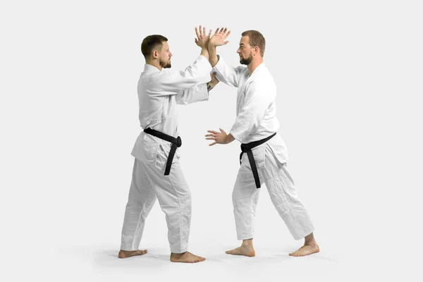 Dois homens caucasianos estão praticando aikido no tatami (isolamento — Fotografia de Stock