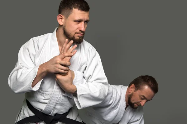 Due uomini caucasici praticano l'aikido sul tatami — Foto Stock