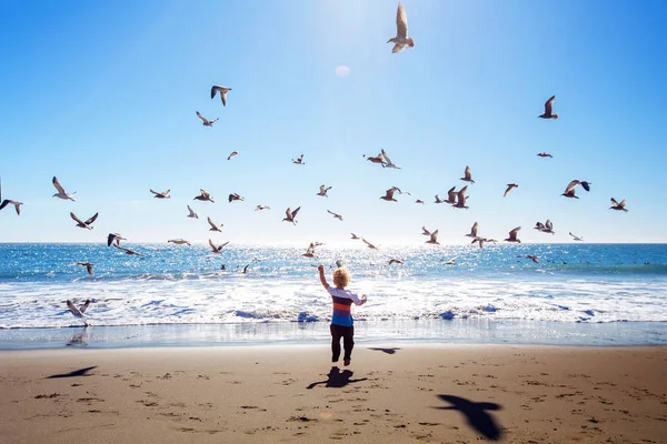 Niño feliz y libre en la playa con gaviotas — Foto de Stock