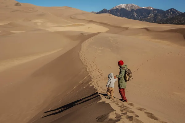 Un hombre con su hijo está de excursión en el desierto — Foto de Stock