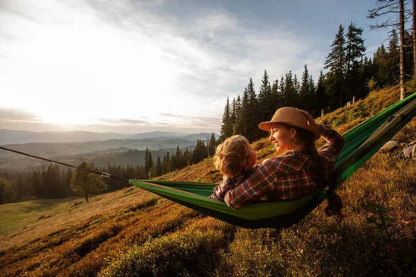 Touristenjunge Ruht Bei Sonnenuntergang Einer Hängematte Den Bergen lizenzfreie Stockfotos