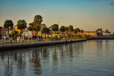 St Augustine, Florida. 26 Ocak 2019. Boardwalk içinde Old Town Florida's Historic kıyılarında, gün batımı arka plan üzerinde yürüyen insanlar