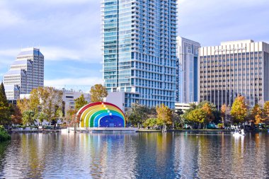 Orlando, Florida. 24 Aralık 2018. Renkli binaları, bulutlu gökyüzü arka planda Orlando Downtown area (1 Lake Eola Park ve Kuğu teknede, sonbahar orman).