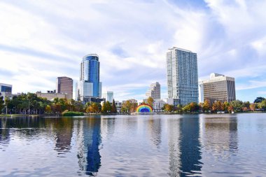 Orlando, Florida. 25 Aralık 2018. Modern binalar, renkli amfitiyatro ve göl Orlando Downtown area Eola Park'ta sonbahar orman.