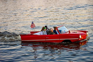 Orlando, Florida; January 11, 2019 People enjoying ride in red amphibious car at Lake Buena Vista area (2). clipart