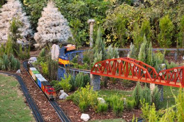 Orlando, Florida. 21 Kasım 2018. Minyatür tren, köprü ve Noel ağacı orman arka planda International Drive alanı üzerinde.