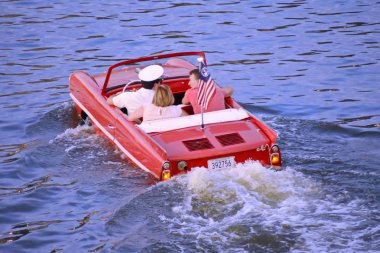 Orlando, Florida. 16 Kasım 2018. Amfibi kırmızı araba zevk güzel bir çift mavi göle Lake Buena Vista alan üzerinde binmek