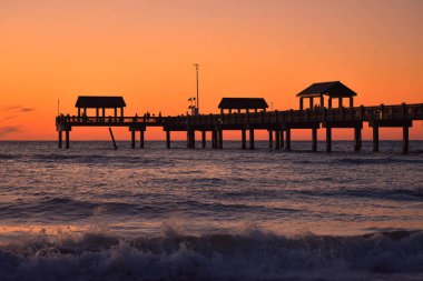 Clearwater, Florida. Ekim 21,2018 Pier 60 kişi ve dalgalar deniz kenarı Clearwater Beach günbatımı renkli arka plan üzerinde siluetleri ile..