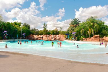 Orlando, Florida. 26 Ekim 2018. İnsanlar havuzu yeşil orman arka plan ve Aquatica Water Park, bulutlu ışık mavi gökyüzü ile düştü ve zevk.
